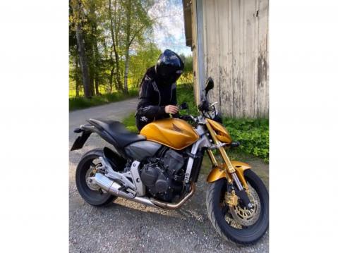 Neea ja kullanvärinen Honda Hornet. Melodiat alkavat syntyä, kun Neea laittaa kypärän päähänsä. Kuva: Neean oma arkisto.